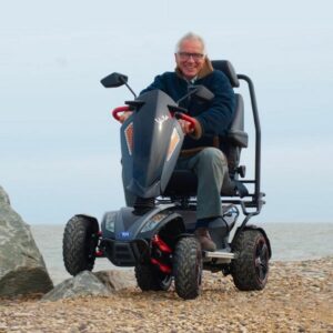 Mobility scooter on the beach drive by older man