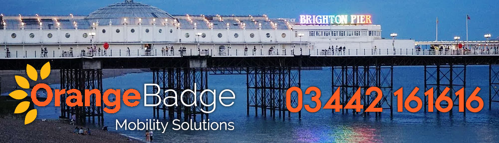 brighton pier at night with orange badge mobility services logo and number for the mobility products in brighton page